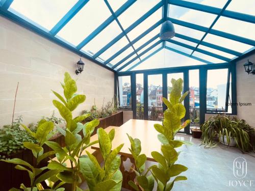 un giardino d'inverno con piante e soffitto in vetro di Joyce Boutique Coffee & Stay a Da Lat