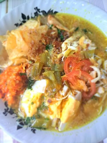 a plate of food with noodles and vegetables at Mocca Guest House in Banyuwangi