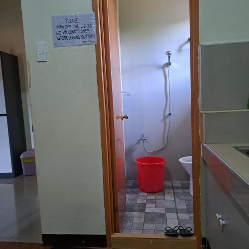 a bathroom with a shower and a red bucket at JZA Transient House in Cagayan de Oro