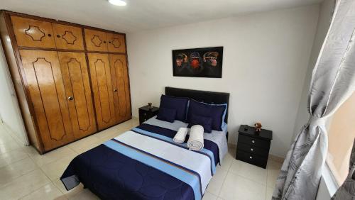 a bedroom with a bed with blue sheets and blue pillows at amplio y comodo apartamento en envigado in Envigado