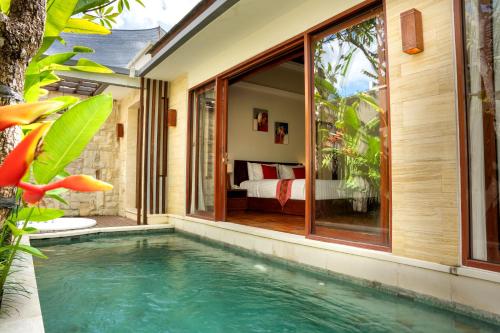 a pool in the backyard of a house with a bedroom at Sanata Luxury Villa in Canggu
