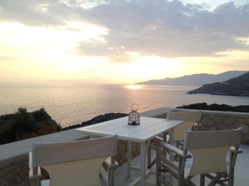 a white table and chairs with a view of the ocean at Katikies Manis in Kardamili
