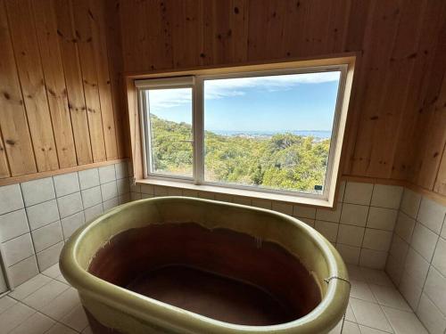 a large tub in a bathroom with a window at SHIRAHAMA condominium D-157 in Kanayama
