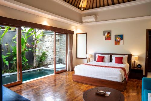 a bedroom with a bed and a swimming pool at Sanata Luxury Villa in Canggu