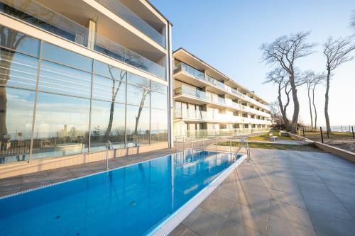 - une vue extérieure sur un bâtiment avec une piscine dans l'établissement HORIZON HEVENIA Rewal Apartament z dużym tarasem i widokiem na morze, à Rewal