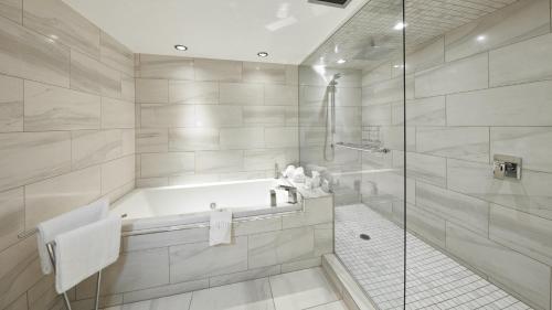 uma casa de banho com uma banheira e um chuveiro em vidro. em Quality Inn Rouyn-Noranda em Rouyn