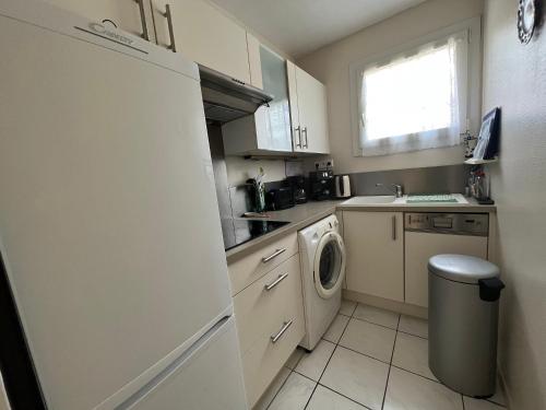 une cuisine avec un réfrigérateur et une machine à laver dans l'établissement Appartement T2 cosy à Arcachon, proche plage, parking sécurisé, balcon-terrasse, Ménage inclus - FR-1-374-115, à Arcachon