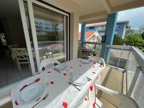 - une table sur un balcon avec un chiffon de table blanc dans l'établissement Appartement T2 cosy à Arcachon, proche plage, parking sécurisé, balcon-terrasse, Ménage inclus - FR-1-374-115, à Arcachon