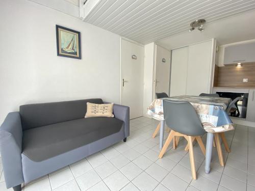 un salon avec un canapé et une table dans l'établissement Maison à 300m de la plage, avec terrasse, parking privatif, animaux admis ! - FR-1-231-140, à Bretignolles-sur-Mer