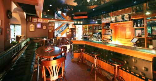 a restaurant with a bar with tables and stools at Penzion Park in Laško