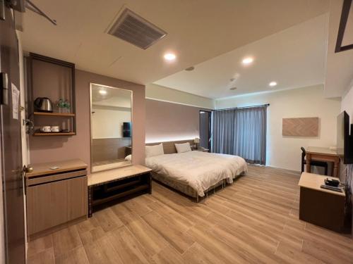 a bedroom with a bed and a large mirror at Sendale Tainan Science Park Hotel in Xinshi