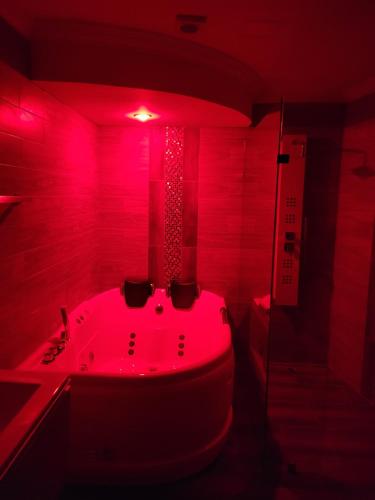 a bathroom with a red lighted tub in a room at Departamento Duplex con Suite in Cuenca