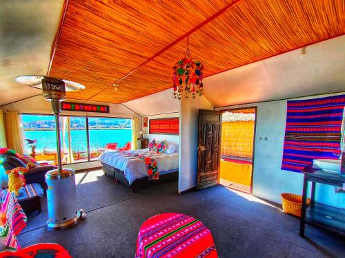 a bedroom with a bed and chairs in a room at Titicaca Origins Perú in Puno
