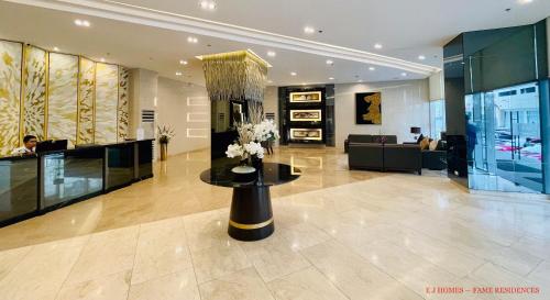 a lobby with a table with flowers on it at MINIMALIST, STYLISH, ELEGANT - at FAME RESIDENCES in Manila