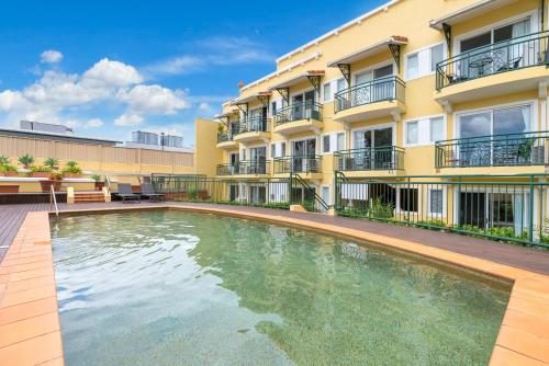 a swimming pool in front of a building at Sapphire Suite- Family friendly in Cairns