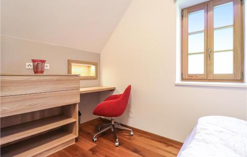a bedroom with a red chair and a desk at Kellerstoeckl In Eltendorf in Eltendorf
