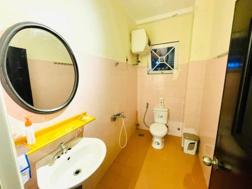 a bathroom with a sink and a mirror and a toilet at Thanh Xuân House in Xuan An