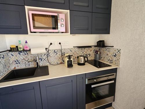 une cuisine avec un évier et un micro-ondes dans l'établissement Superbe duplex à 200m de la plage avec terrasse et garage - FR-1-71-99, à Saint-Georges-de-Didonne