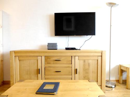 - une télévision à écran plat sur une commode en bois dans l'établissement Appartement rénové 8p à Tignes · Proche pistes et commerces · Balcon · Sud · Animaux acceptés - FR-1-502-508, à Tignes