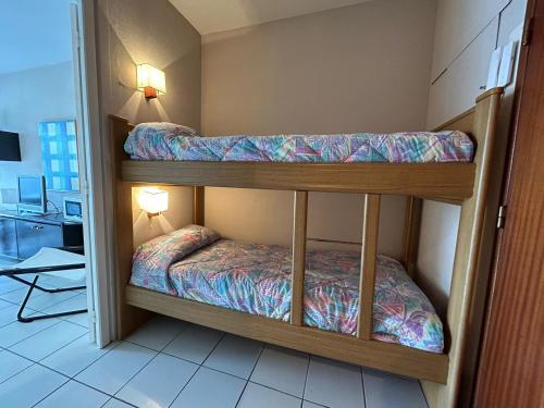 Ce dortoir comprend 2 lits superposés et une salle de bains. dans l'établissement Appartement avec Terrasse Proche Plage et Parking Gratuit - FR-1-239-955, à Urrugne