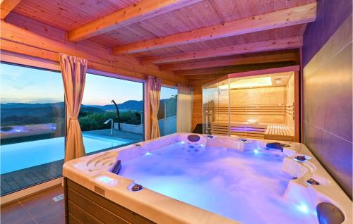 a large bath tub in a room with a large window at Four-bedroom Holiday Home in Lepajci