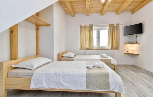 a bedroom with two beds and a tv on the wall at Four-bedroom Holiday Home in Lepajci