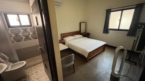 馬公市的住宿－喵鯊民宿，一间卧室配有一张床,浴室设有淋浴。