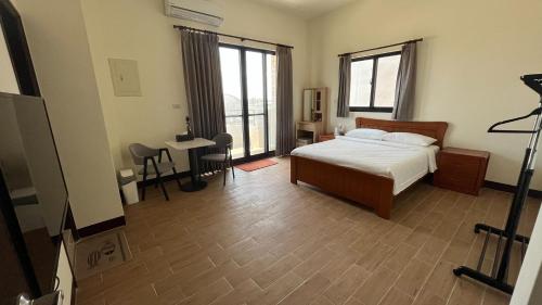 een slaapkamer met een bed en een tafel in een kamer bij Sharkat Homestay in Magong