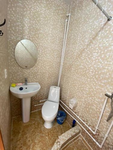a bathroom with a sink and a toilet and a mirror at Квартира-студия недорого напротив парка Металлургов in Ustʼ-Kamenogorsk