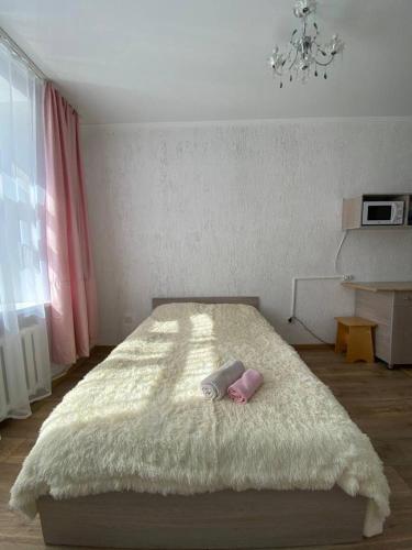 a bedroom with a large bed with a white blanket at Квартира-студия недорого напротив парка Металлургов in Ustʼ-Kamenogorsk