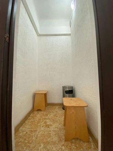 une petite chambre avec deux tables et une poubelle dans l'établissement Квартира-студия недорого напротив парка Металлургов, à Öskemen