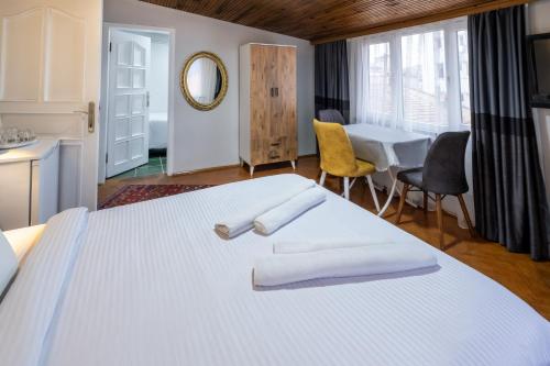 a bedroom with a white bed with two towels on it at İSTANBLUE TAKSİM APART HOTEL in Istanbul