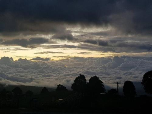 a group of clouds in the sky at sunset at Cabaña Montaña de Sueños in Quesada