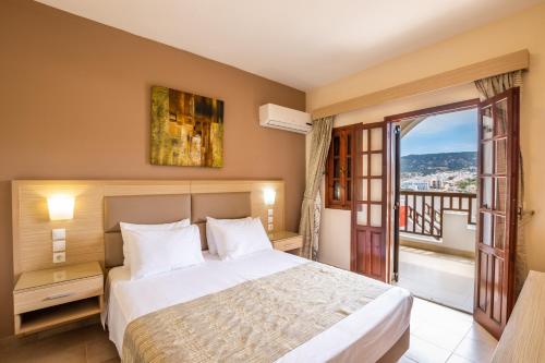a hotel room with a bed and a balcony at Aphrodite Luxury Studios & Apartments in Karpathos