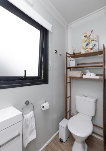 a bathroom with a white toilet and a window at 2 Peas In A Pod in Wellington