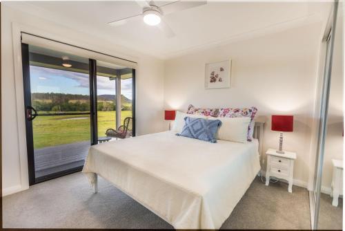 a bedroom with a bed and a large window at Clarrie's Green in Clarence Town