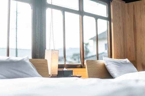 a bedroom with a bed and a large window at Nipponia 甲佐 疏水の郷 in Kosa
