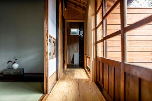a hallway of a house with wooden walls and wooden floors at Nipponia 甲佐 疏水の郷 in Kosa
