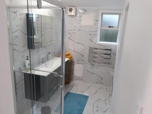 a bathroom with a shower and a sink at Garden studio in Motueka