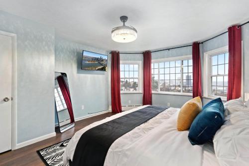 a bedroom with a large bed with red curtains at Stay Golden 1: Chic Modern-Victorian City View in Pittsburgh