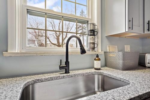 a kitchen with a sink and a window at Stay Golden 1: Chic Modern-Victorian City View in Pittsburgh