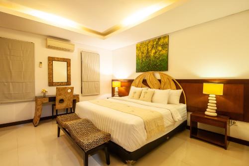 Sanur Beach Villa - 3BR Private Pool في سانور: غرفة نوم بسرير كبير في غرفة