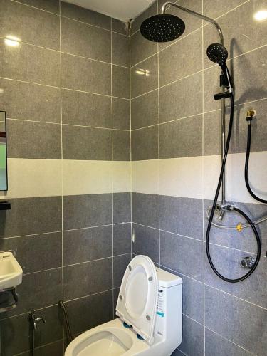 a bathroom with a toilet and a shower at Sri Aman Homestay in Jitra