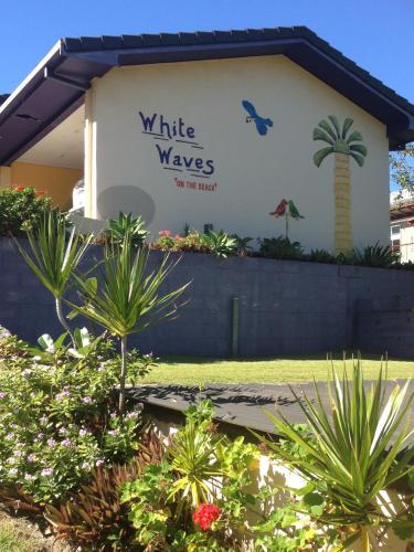 a building with a sign that reads white waves at White Waves on the Beach in Hastings Point