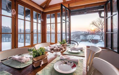 jadalnia ze stołem i oknami w obiekcie Cozy Home In Beretinec With Sauna w mieście Beretinec