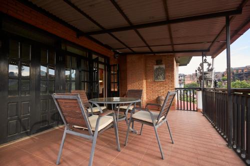 a patio with a table and chairs on a balcony at Himalayan Hideaway in Tanahun