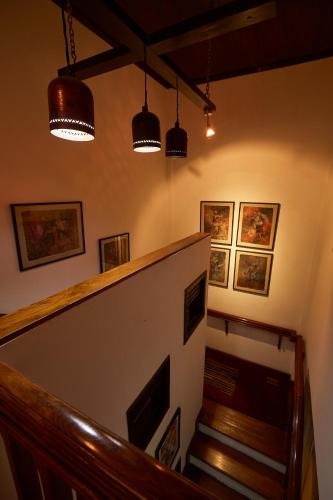 a staircase with three lights and some pictures on the wall at Himalayan Hideaway in Tanahun