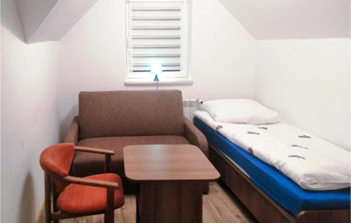 Cette petite chambre comprend un lit, une table et une chaise. dans l'établissement Amazing Home In Ilawa With Wifi, à Iława