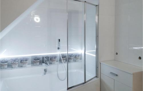 a white bathroom with a shower with potted plants at Amazing Home In Ilawa With Wifi in Iława