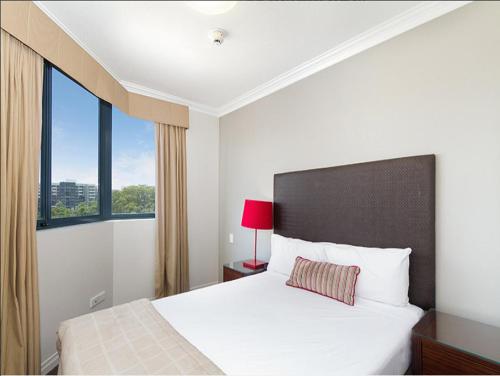 a bedroom with a bed with a large window at Shevlin Apartments in Brisbane